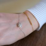 Close-up of a woman's wrist wearing a luxurious diamond and gold bracelet, highlighting elegance.